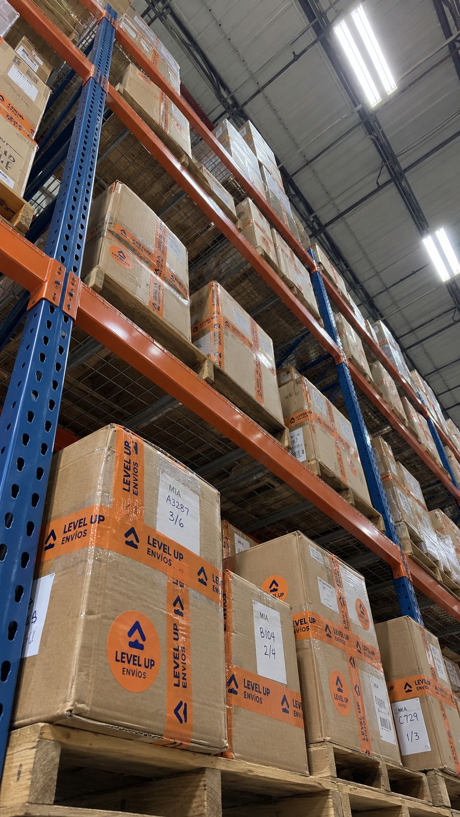 Estantes del almacén con cajas identificadas de Level Up Envíos